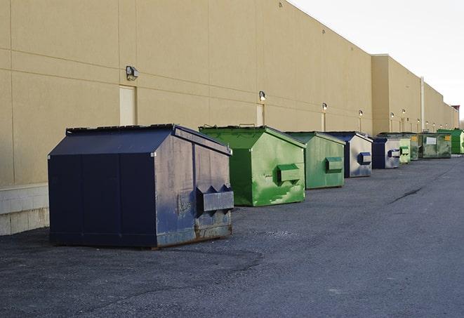 a pile of demolition waste sits beside a dumpster in a parking lot in Loraine TX